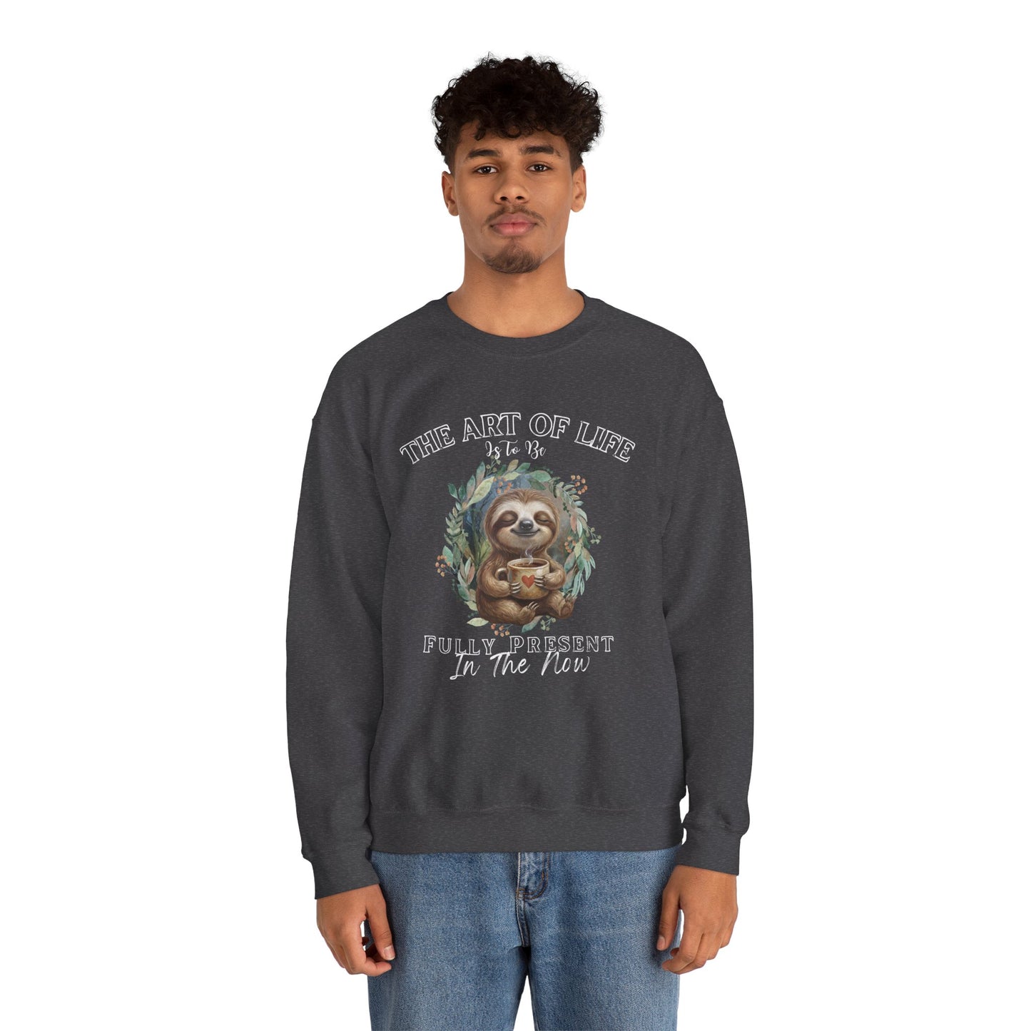 Man wearing a dark gray sweatshirt with a sloth drinking coffee graphic and text 'The art of life is to be fully present in the now' on a white background