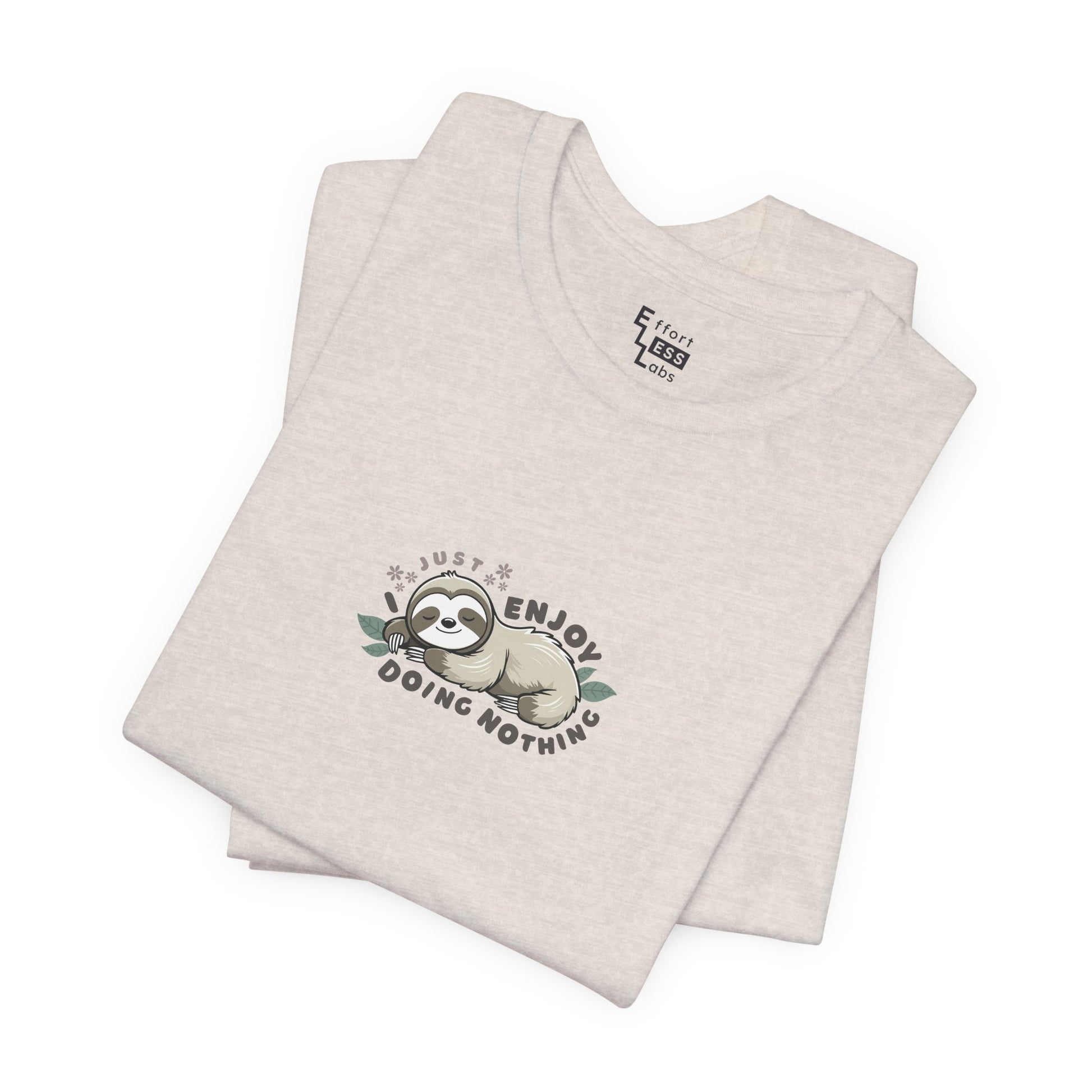 Folded almond beige t-shirt with a sloth graphic and text 'I just enjoy doing nothing' on a white background
