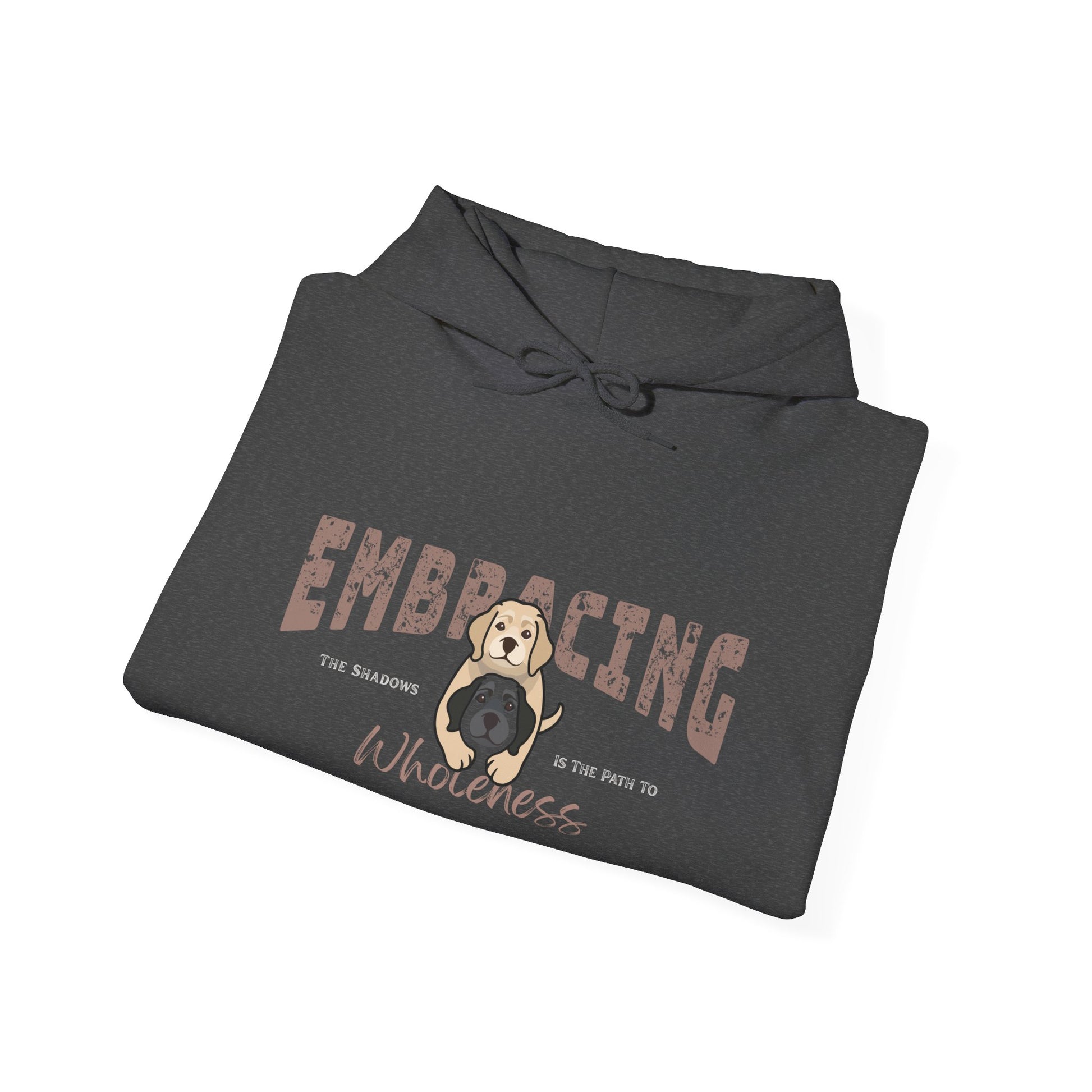 Folded dark gray hoodie with a graphic of yellow Labrador Retriever hugging black Labrador Retriever and text 'Embracing the shadows in the path to wholeness' on a white background