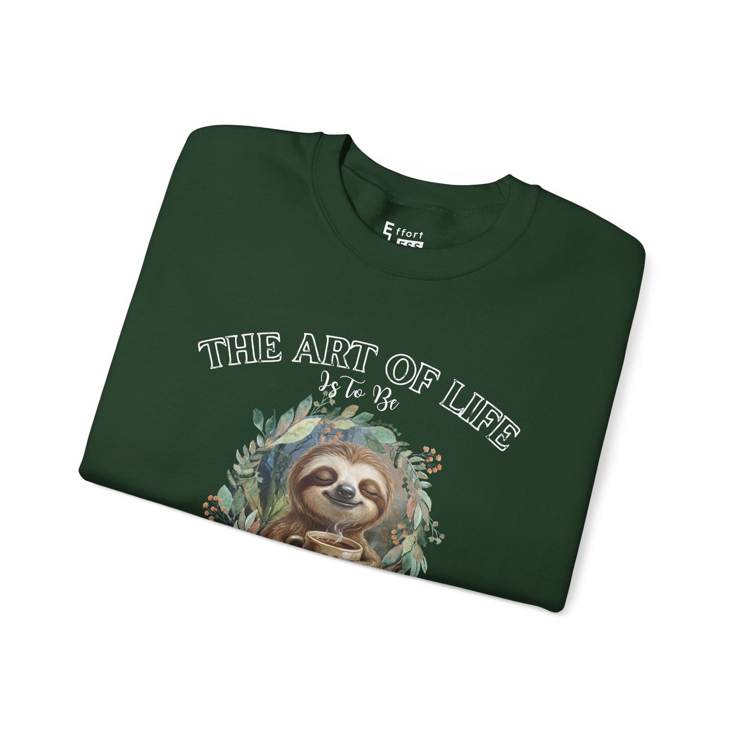 Folded dark green sweatshirt with a sloth drinking tea graphic and text 'The art of life' on a white background