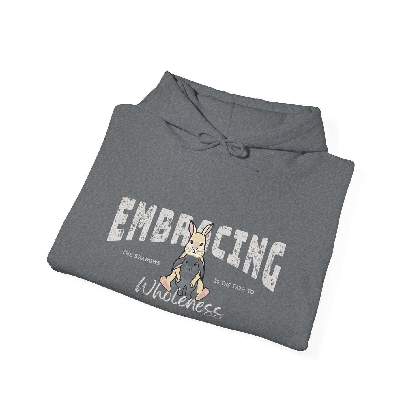 Folded blue-gray hoodie with a graphic of cream Holland Lop rabbit hugging gray Holland Lop rabbit and text 'Embracing the shadows is the path to wholeness' on a white background
