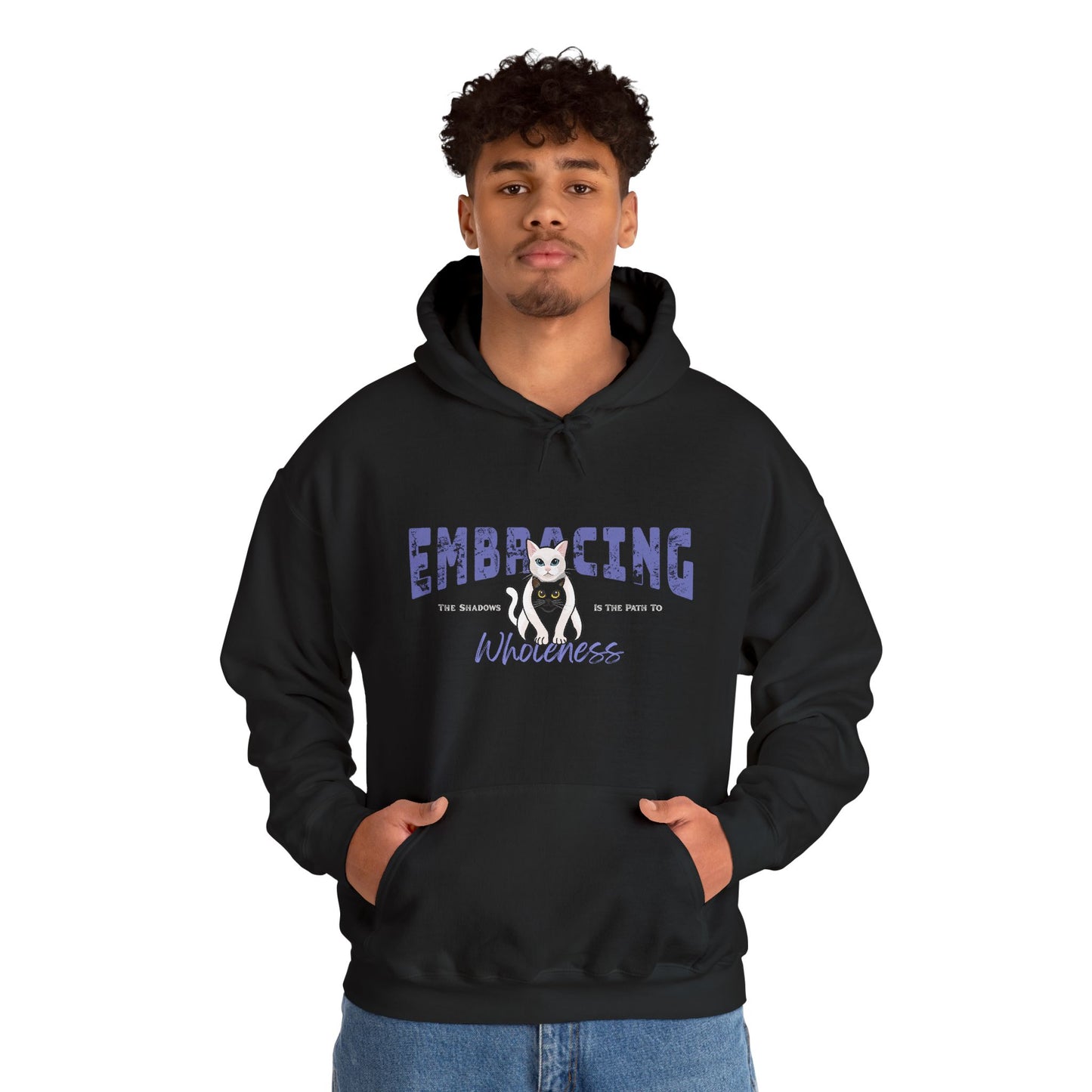 Man wearing a black hoodie with a graphic of white cat hugging black cat and text 'Embracing the shadows is the path to wholeness' on a white background
