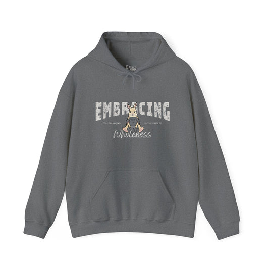Blue-gray hoodie with a graphic of cream Holland Lop rabbit hugging gray Holland Lop rabbit and text 'Embracing the shadows is the path to wholeness' on a white background