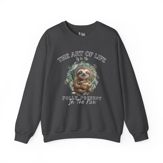 Dark gray sweatshirt with a graphic of sloth drinking coffee and text 'The art of life is to be fully present in the now' on a white background