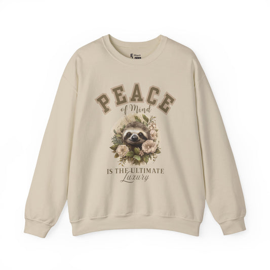 Sand beige sweatshirt with floral sloth graphic and text 'Peace of mind is the ultimate luxury' on a white background
